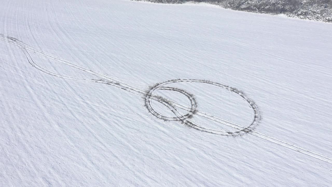 飞行在雪山与轮胎痕迹4K无人机视频视频素材