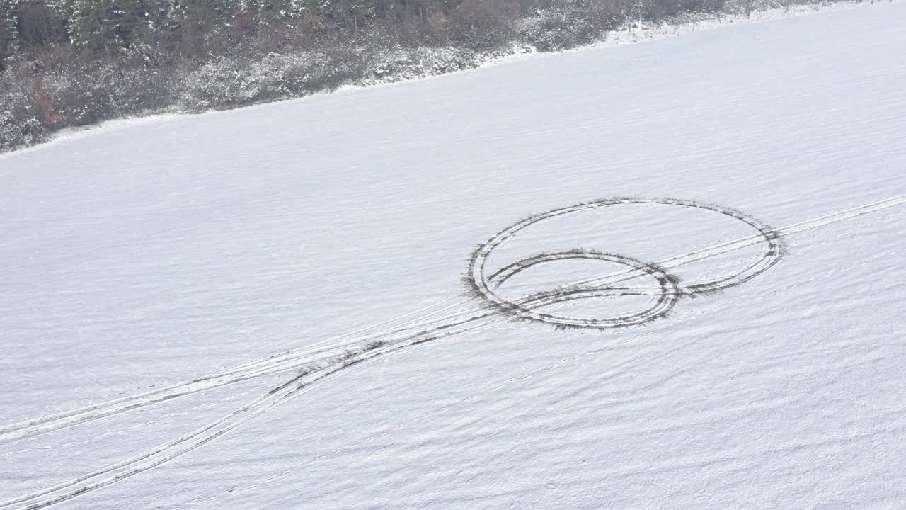 在有轮胎印的雪山上旋转。4 k无人机视频视频素材