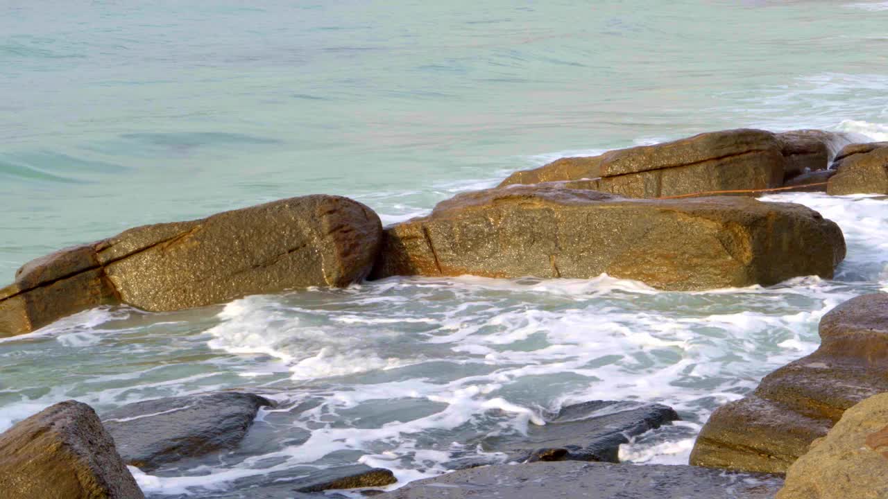 海浪拍打着海滩上的岩石。泰国罗勇岛的景色视频素材