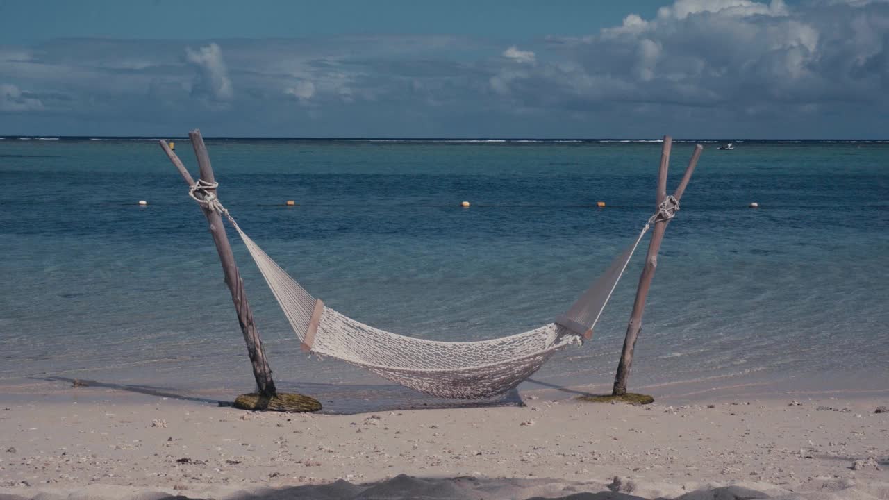 放松的热带风景-吊床海滩上透明的海洋，船只和蓝天毛里求斯视频素材