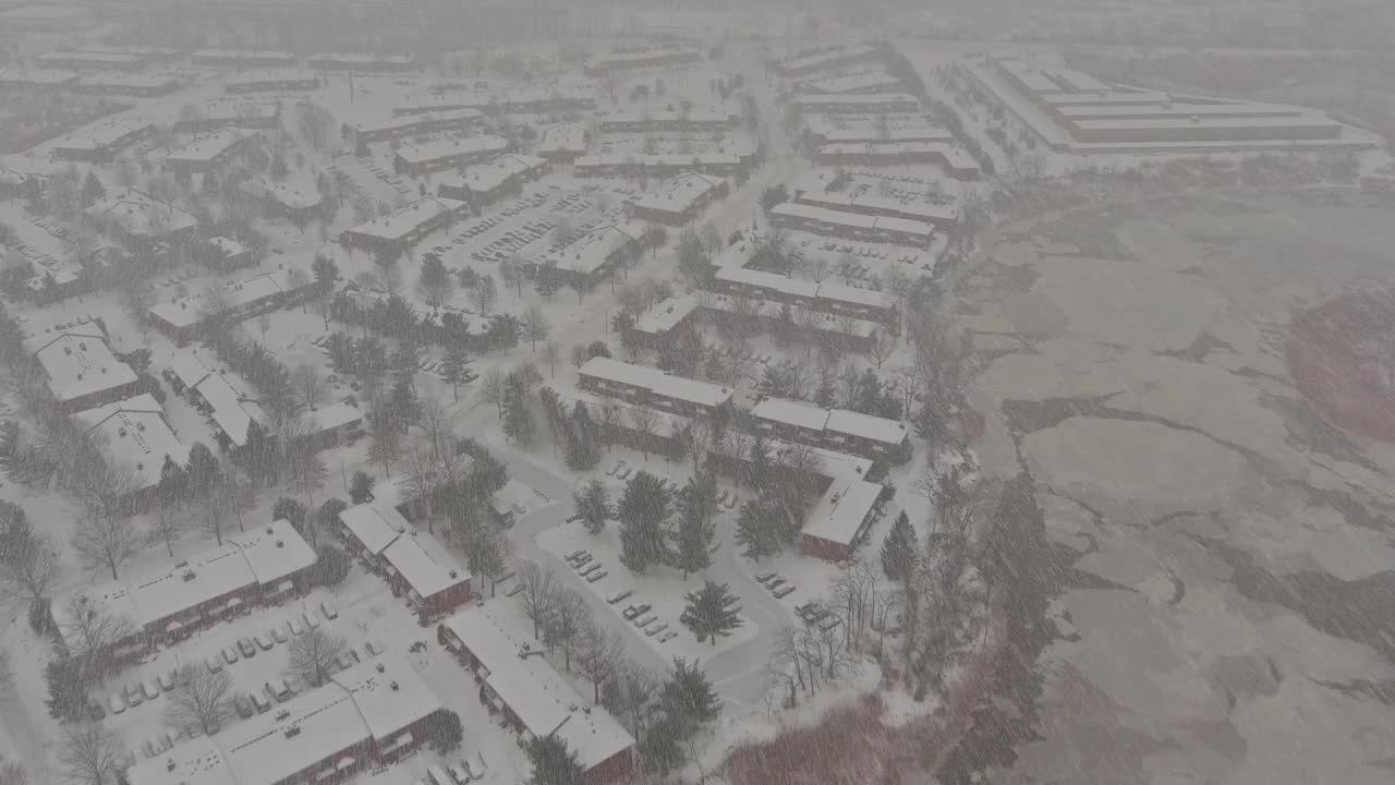 鸟瞰图一个冬天下雪的日子风景屋顶房子下雪后的居民小镇在冬天的一天视频素材