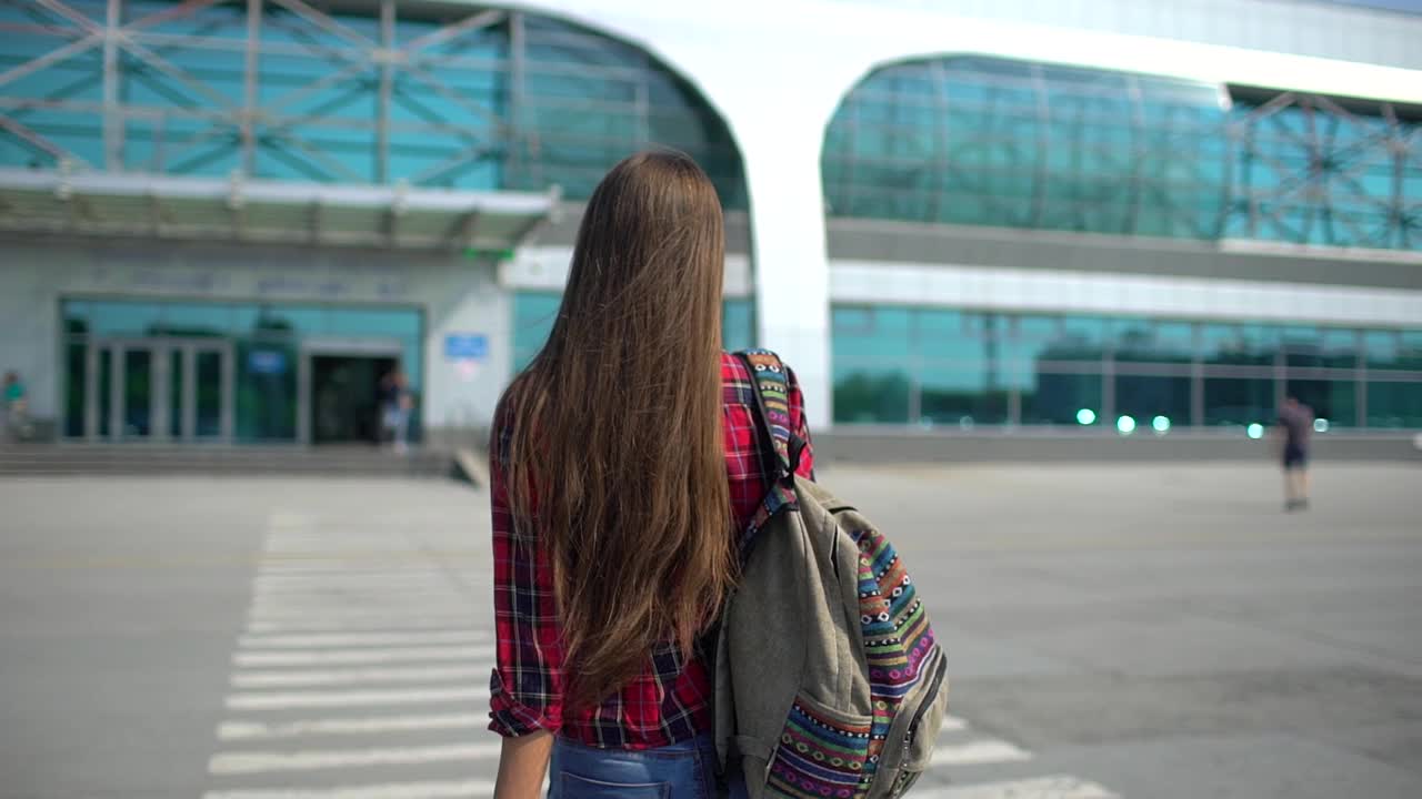 年轻女子正走向现代化的机场候机楼准备登机视频素材