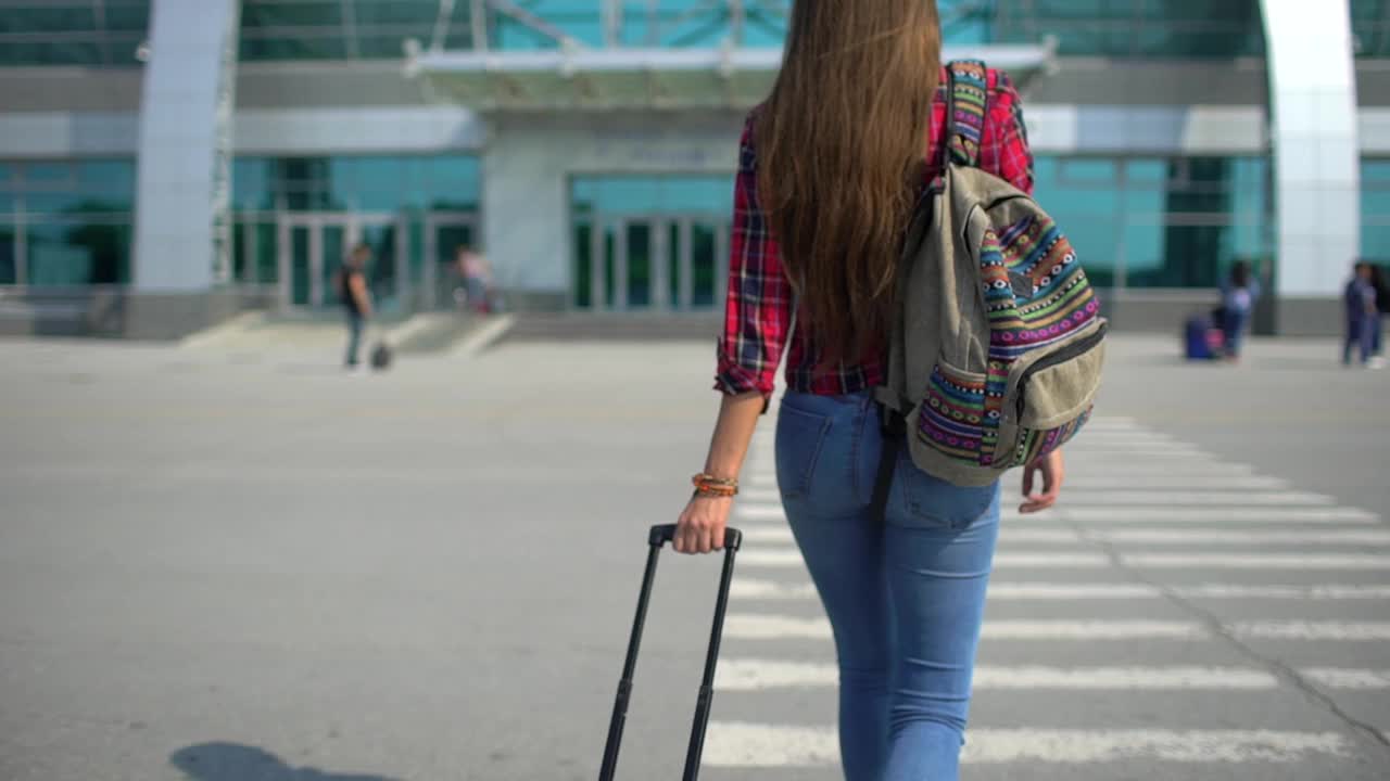 年轻女子正走向现代化的机场候机楼准备登机视频素材