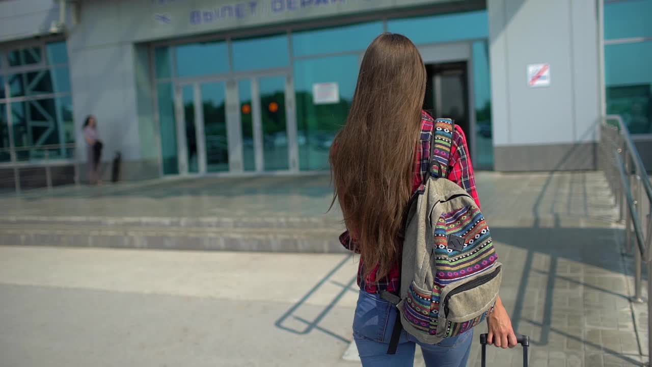 年轻女子正走向现代化的机场候机楼准备登机视频素材