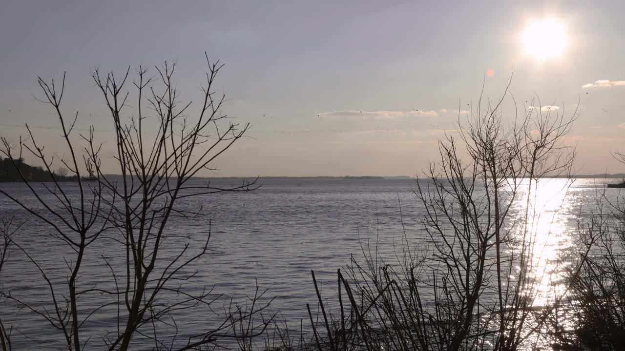 时间在河边流逝，背景是美丽的日落视频素材