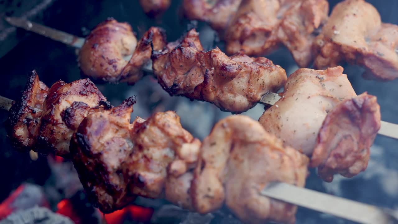 在木炭烤架上用鸡肉串烤。近距离视频素材