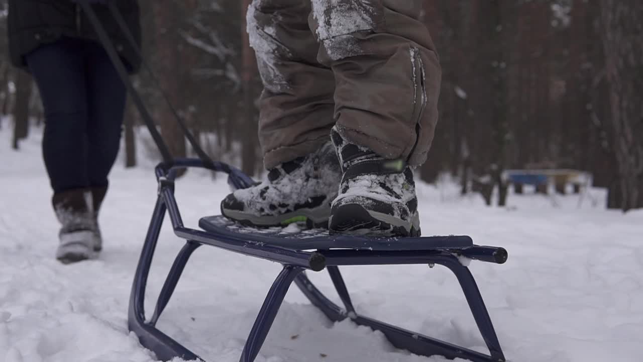 那家伙站着滑雪橇。冬季好玩的儿童隔离。视频素材