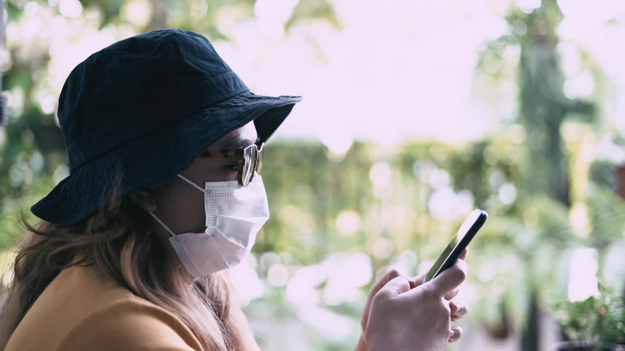 戴着面具用手机的女人视频素材