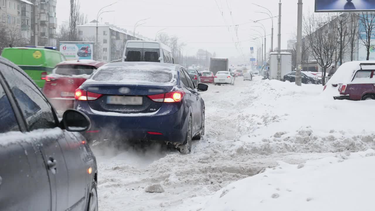 冬天下雪时城市道路上的汽车交通。视频素材