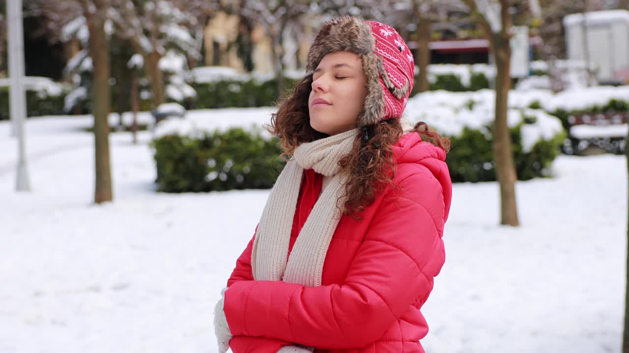 年轻女子正在享受下雪的冬日视频素材