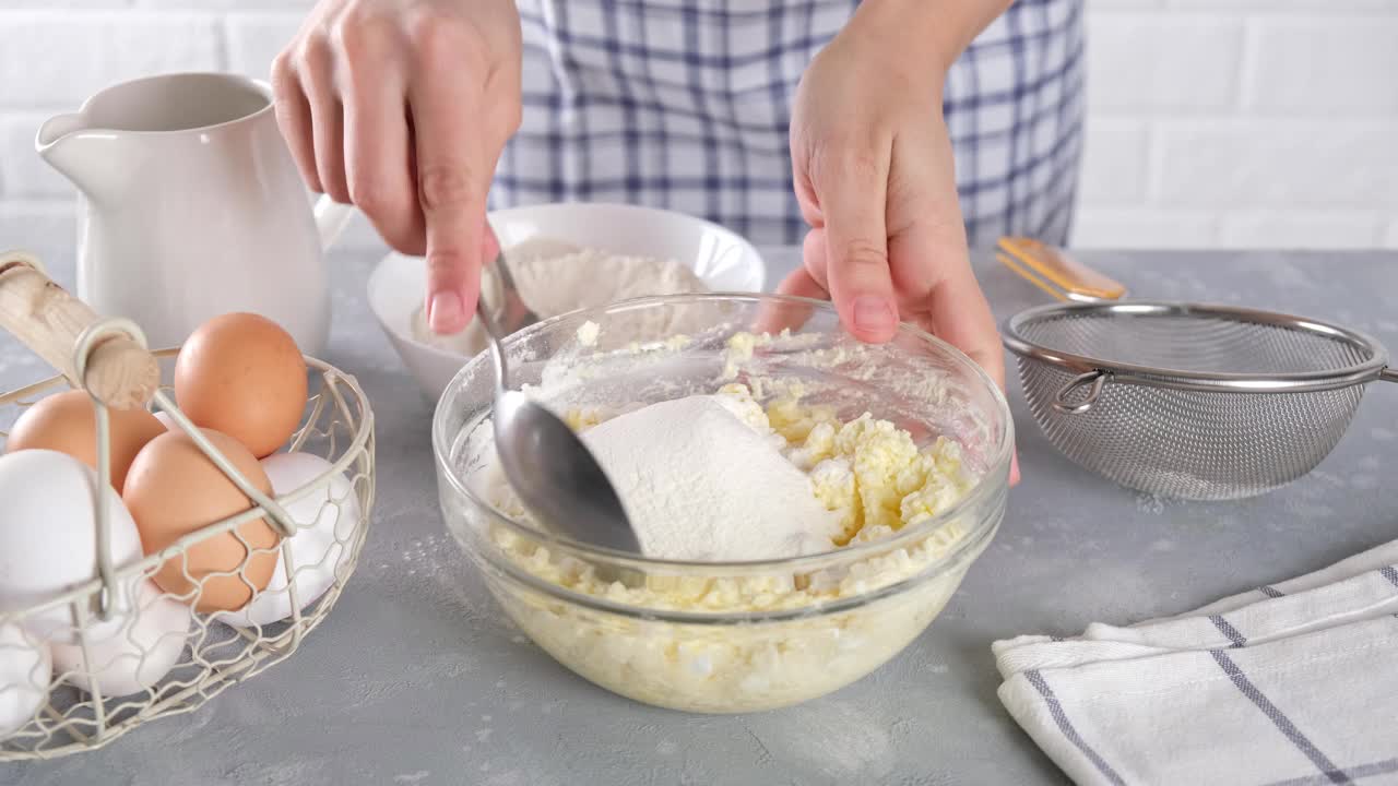 做白干酪煎饼，瑟妮基。生面团的准备，糕点的制作。在家做饭的女人视频素材