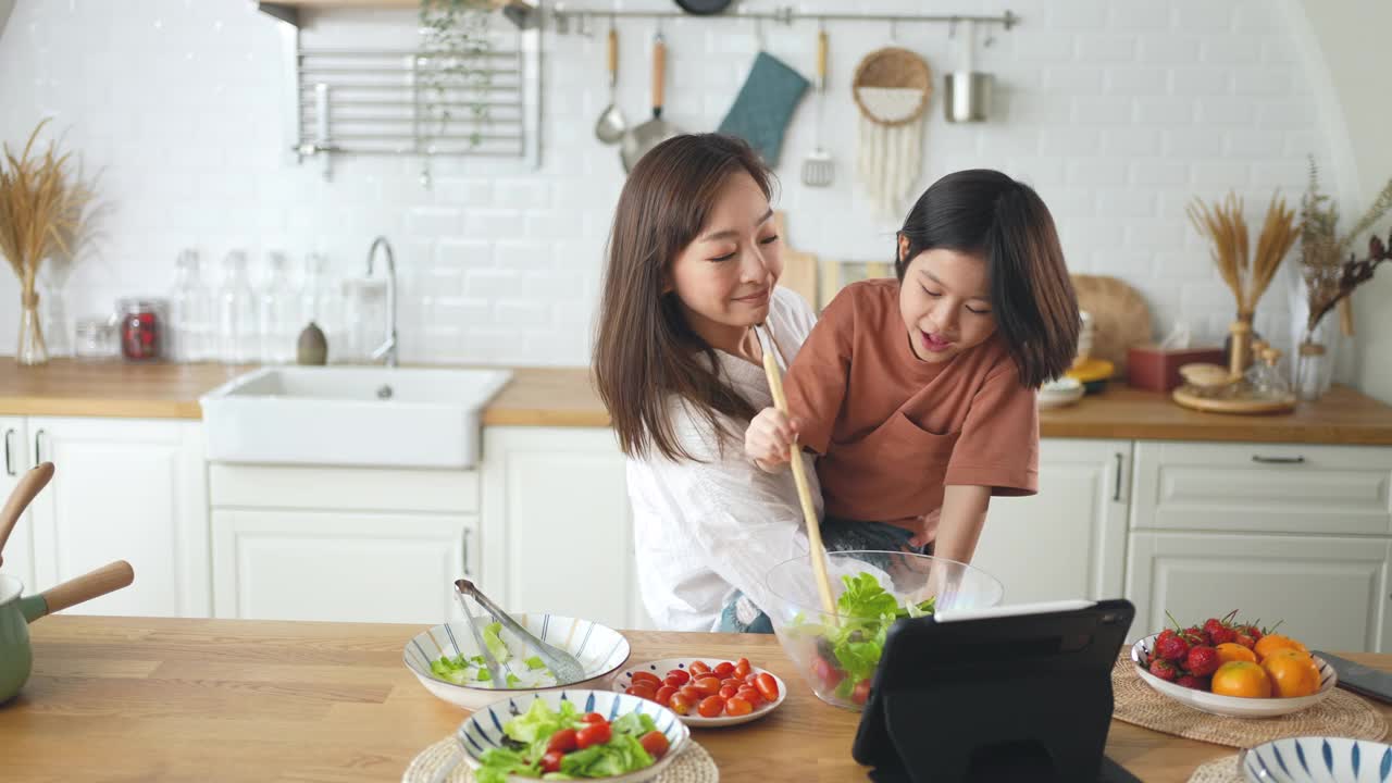 母女俩在厨房里做沙拉视频素材