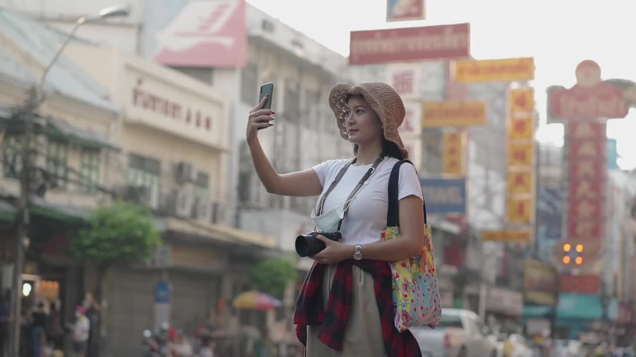 《亚洲旅行者》的博客女性在泰国曼谷旅游，美丽的女性用手机制作视频博客并在社交媒体上生活。视频素材