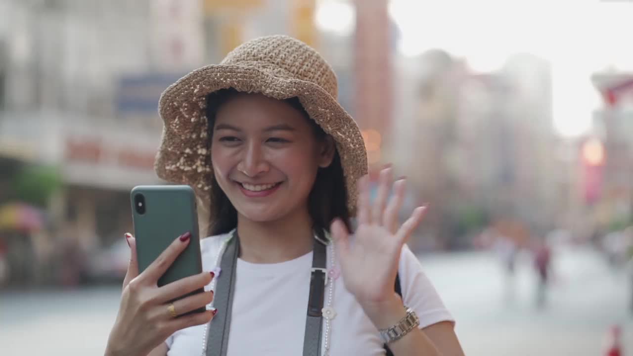 《亚洲旅行者》的博客女性在泰国曼谷旅游，美丽的女性用手机制作视频博客并在社交媒体上生活。视频素材