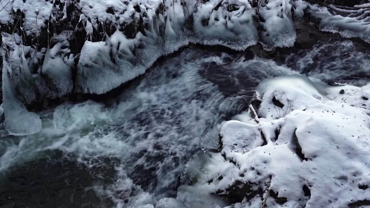 冻结的山河流过冰冷的岩石和积雪视频下载