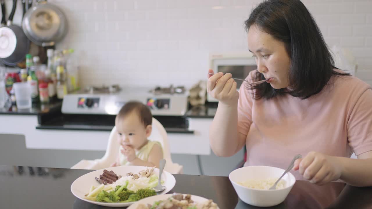 亚裔泰国妈妈和她的孩子吃饭视频素材