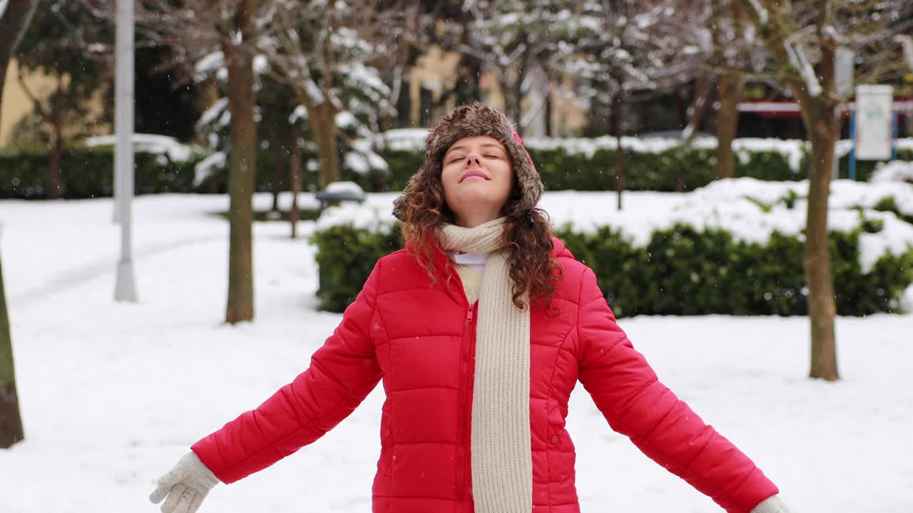 年轻女子正在享受下雪的冬日视频素材