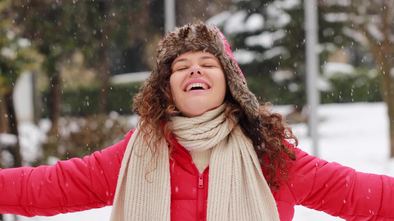 年轻女子正在享受下雪的冬日视频素材