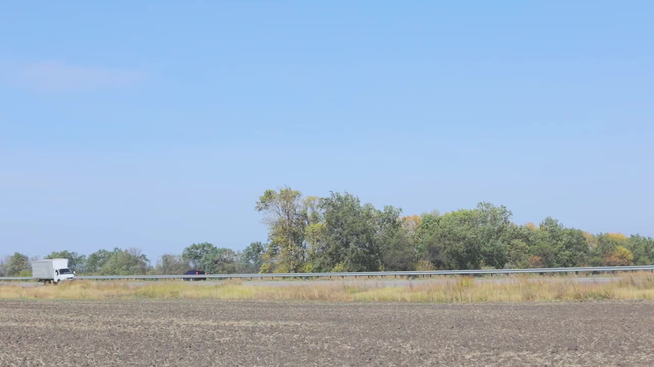 卡车在公路上行驶。卡车绕着田野和树林在公路上行驶视频素材