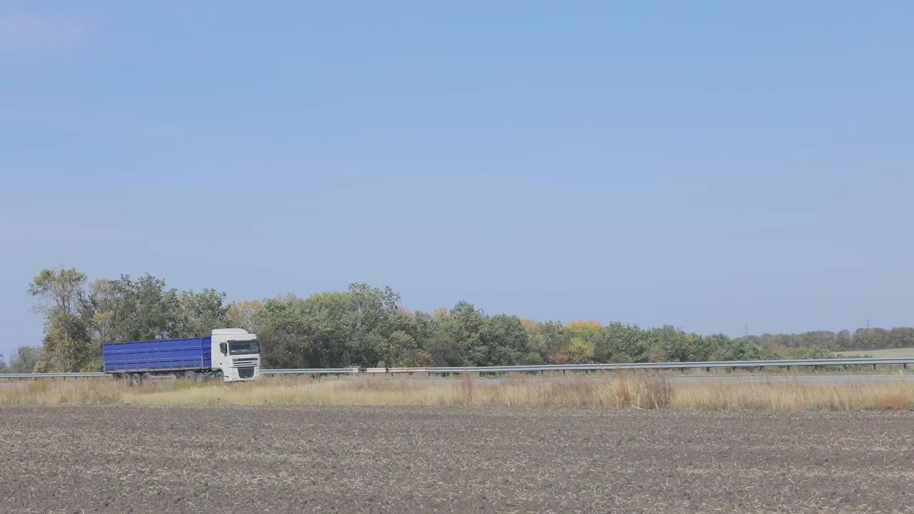 一辆卡车在城外的路上行驶，一辆现代货运卡车在高速公路上行驶视频素材