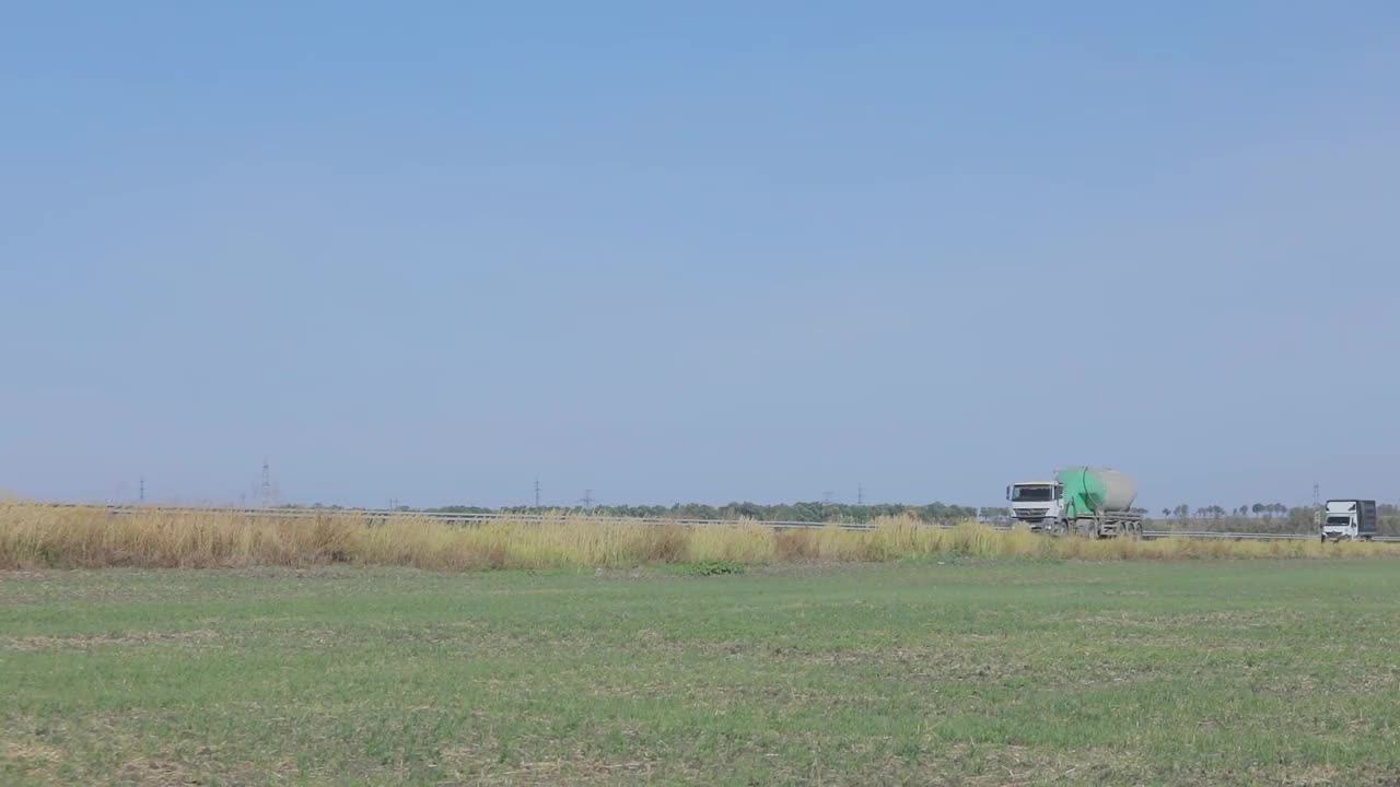 卡车在公路上行驶。卡车绕着田野和树林在公路上行驶视频素材