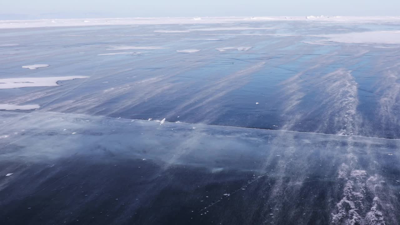 白雪在贝加尔湖的蓝色冰面上飞舞视频素材