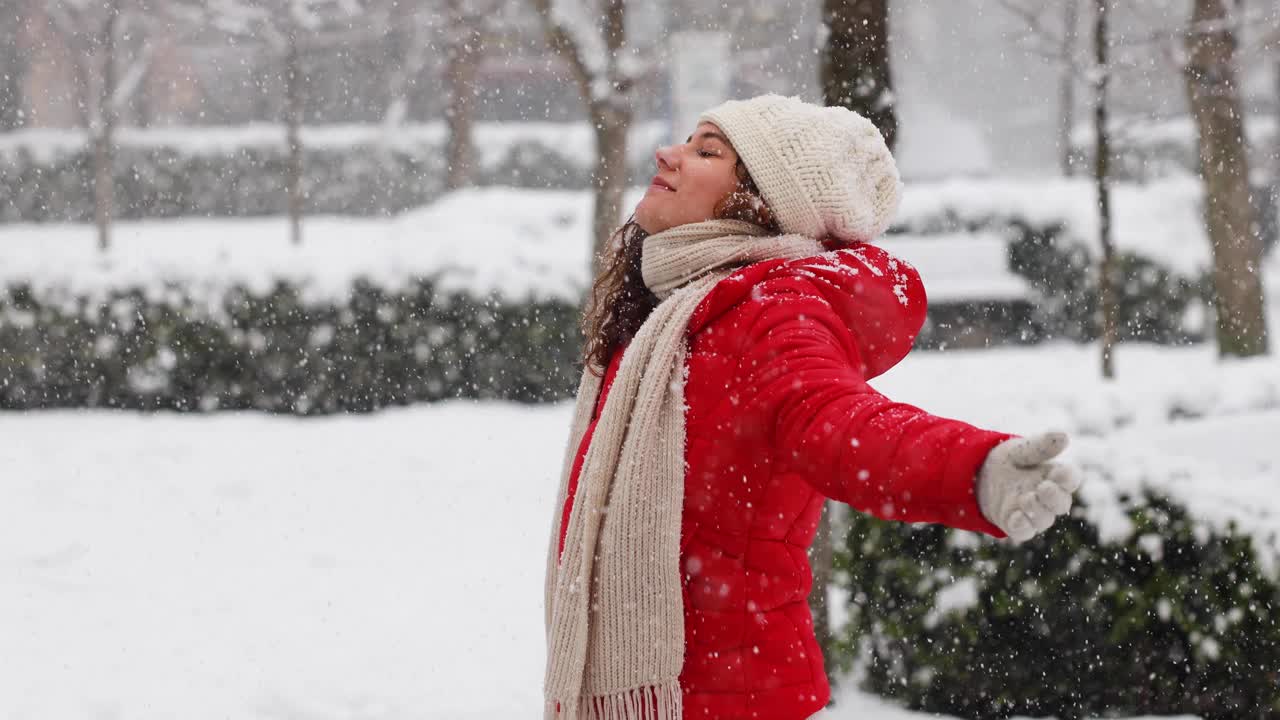 年轻女子正在享受下雪的冬日视频素材