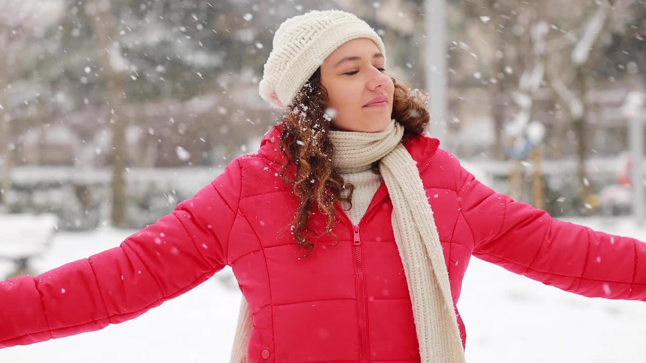 年轻女子正在享受下雪的冬日视频素材