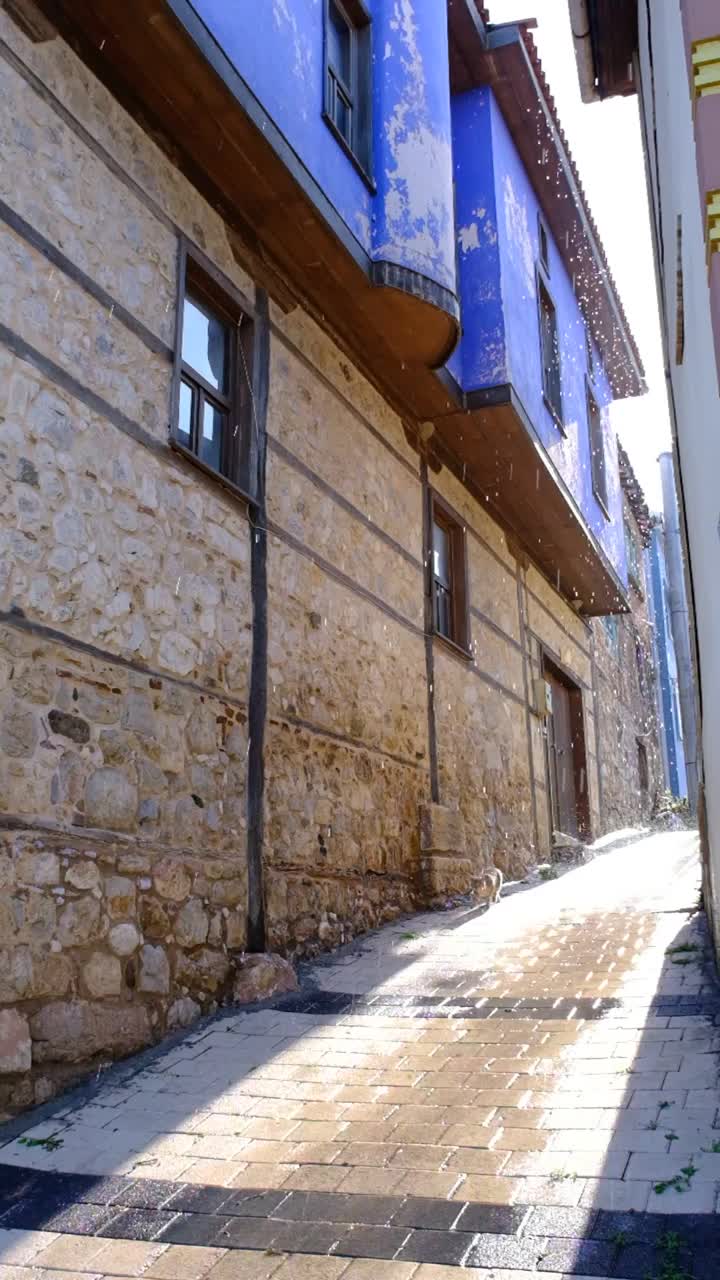 古老的奥斯曼风格的房子与蓝色和狭窄的街道与阳光视频素材