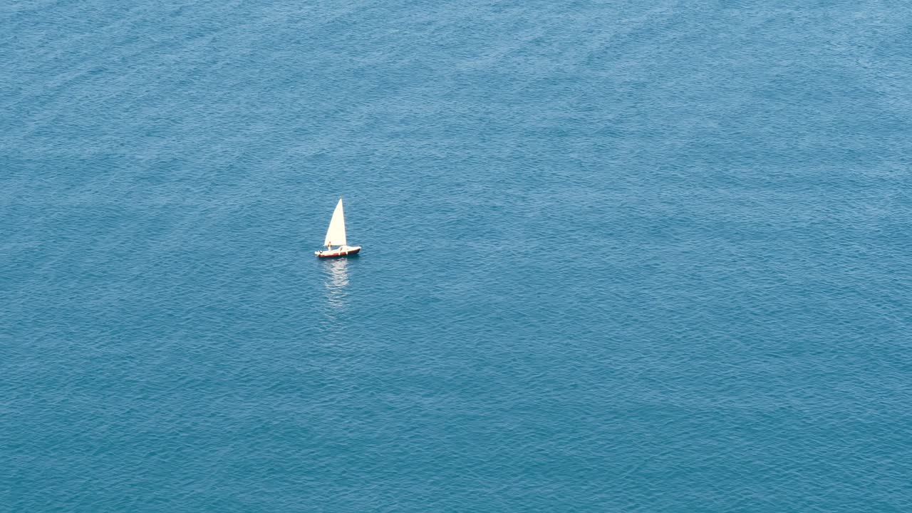 在热带绿松石海水上航行的小船的鸟瞰图和风在海面上制造小波浪。暑假，异国风情的旅游胜地视频素材