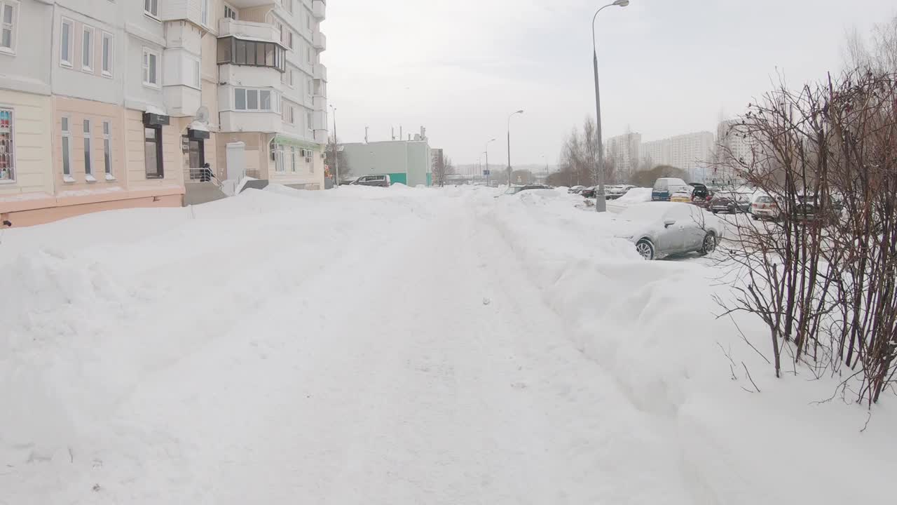 一场大雪过后，在莫斯科城市住宅区清理公园的小路视频素材