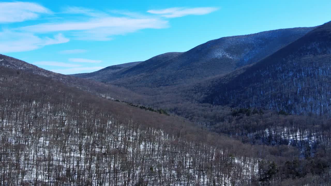 一架无人机拍摄的晴朗的雪山山谷，蓝天和一些云彩视频素材