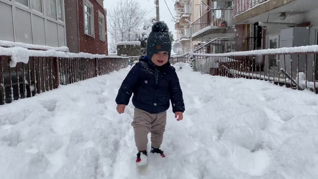 可爱的男孩在冬天的雪地里玩耍视频素材