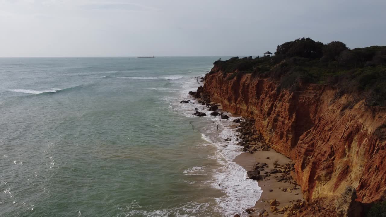 海浪拍打着荒芜的海滩上的悬崖视频素材