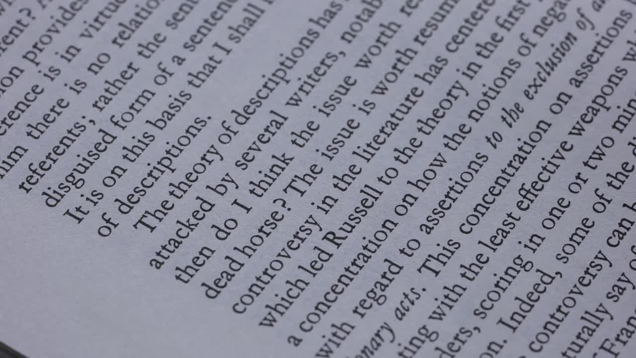 在打开的书的一页上详细查看英文文本。一名男子在慢镜头中带领一支铅笔沿着线条前进。近距离视频素材