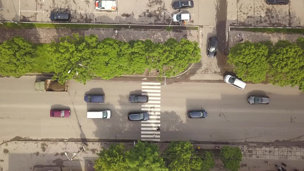 空中俯瞰街道上移动的汽车和斑马线与过街行人。视频素材