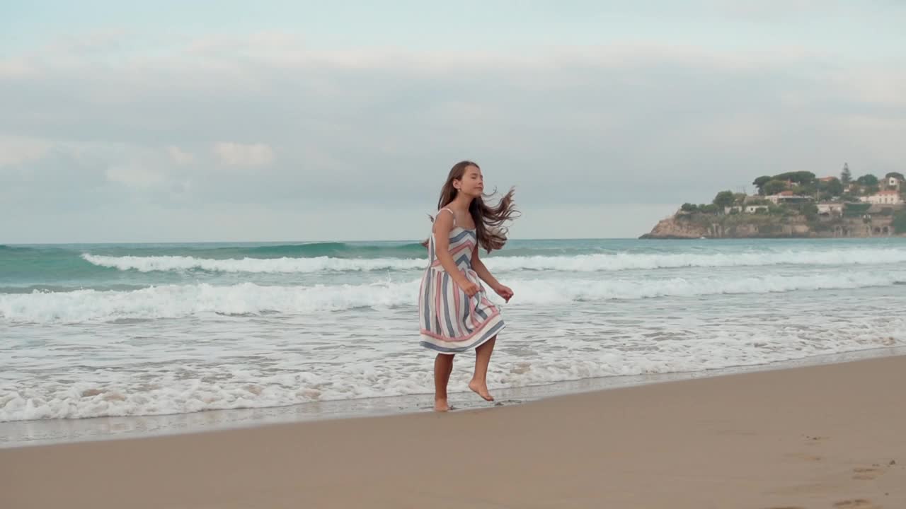 微笑的女人在海边享受假期。快乐的女孩在海边跳舞。视频素材