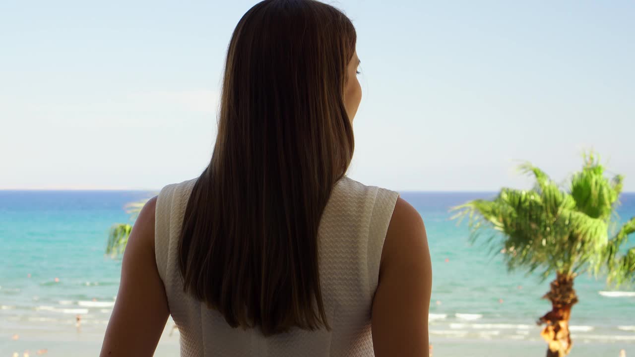 站在阳台上欣赏风景的女人。女性度假看地中海视频素材