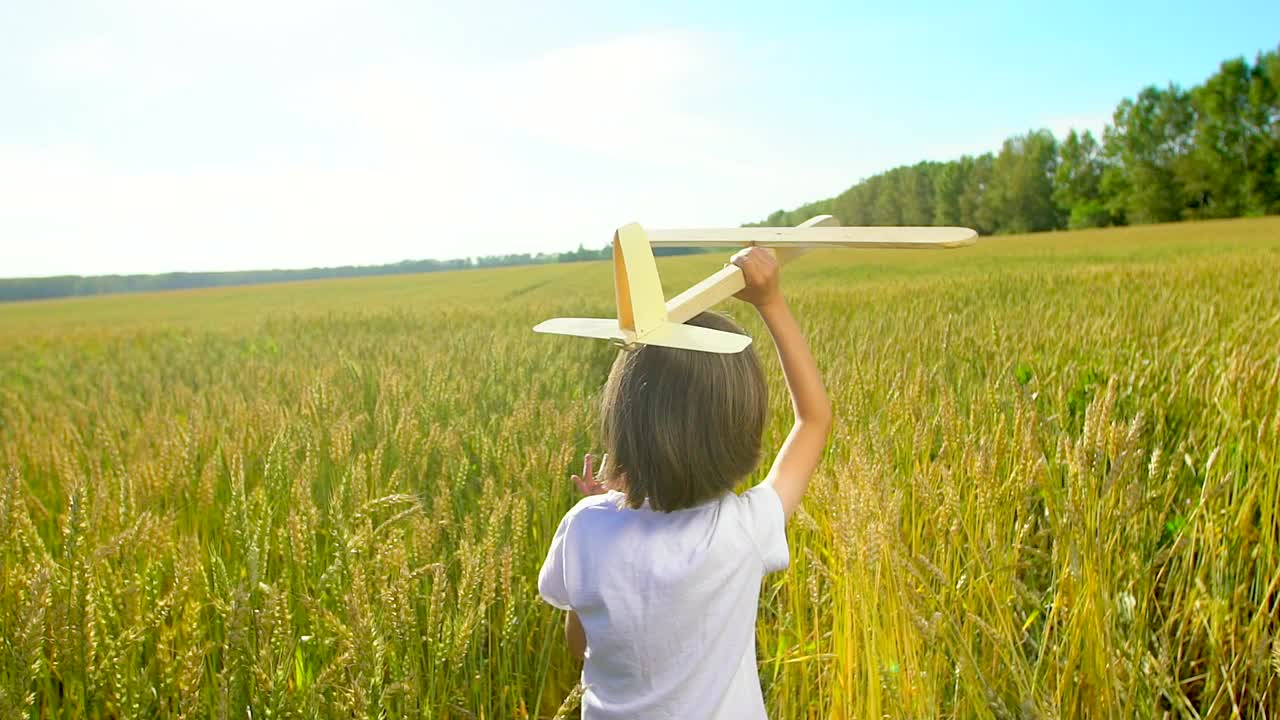 快乐的小男孩和玩具飞机在麦田在日落。孩子们在夏天的户外玩飞机。梦想飞行的小飞行员，和幸福的家庭一起度假。大的梦想视频素材