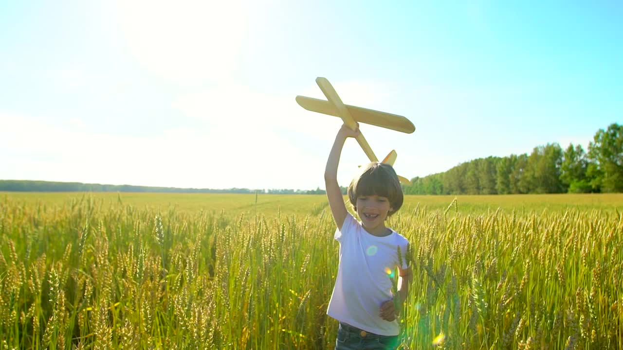 快乐的小男孩和玩具飞机在麦田在日落。孩子们在夏天的户外玩飞机。梦想飞行的小飞行员，和幸福的家庭一起度假。大的梦想视频素材