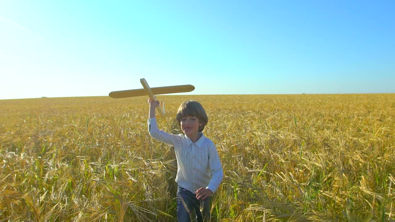 快乐的小男孩和玩具飞机在麦田在日落。孩子们在夏天的户外玩飞机。梦想飞行的小飞行员，和幸福的家庭一起度假。大的梦想视频素材