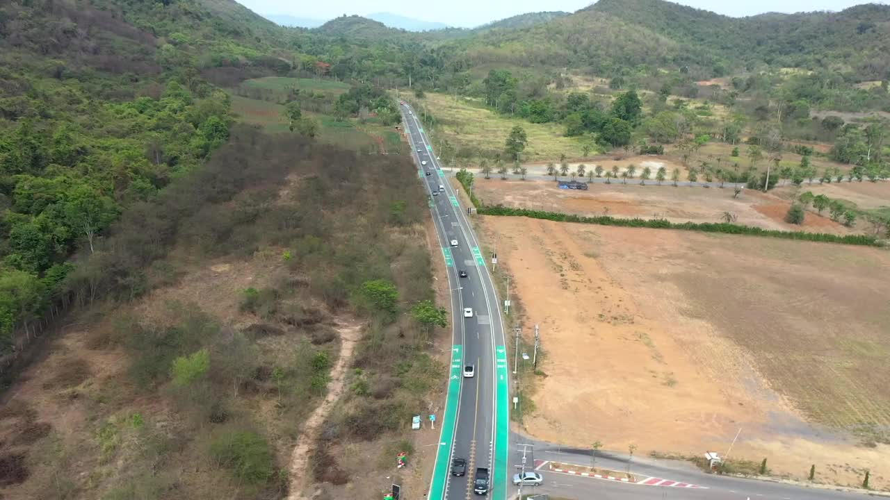 鸟瞰公路上行驶的汽车，路旁有森林和沼泽视频素材