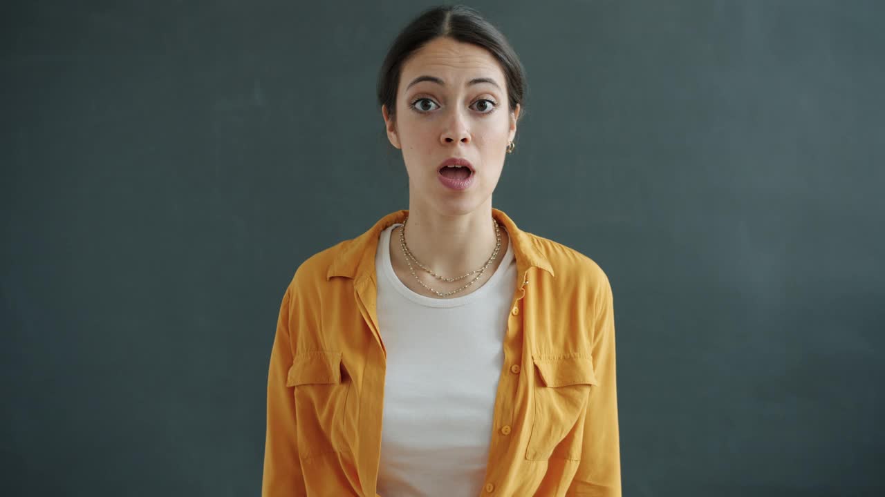 慢动作肖像的可爱的年轻女子显示拇指向上的手势和指向自己视频素材