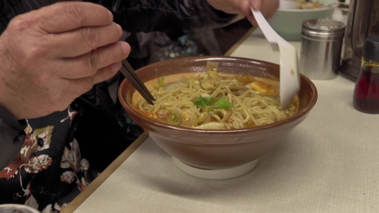 饥饿的老人吃拉面，日本面条的高汤视频素材