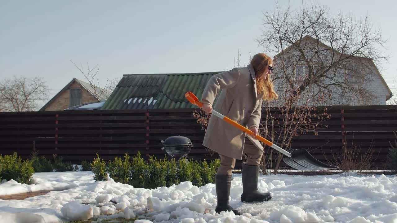 一位妇女用铲子清扫积雪视频素材