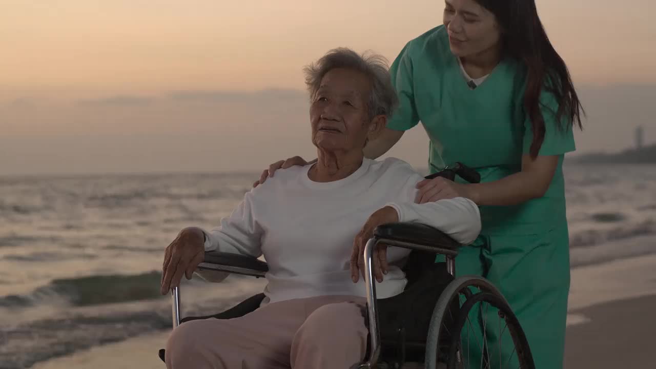 坐在轮椅上的老妇人。她笑着和女儿谈话。视频素材