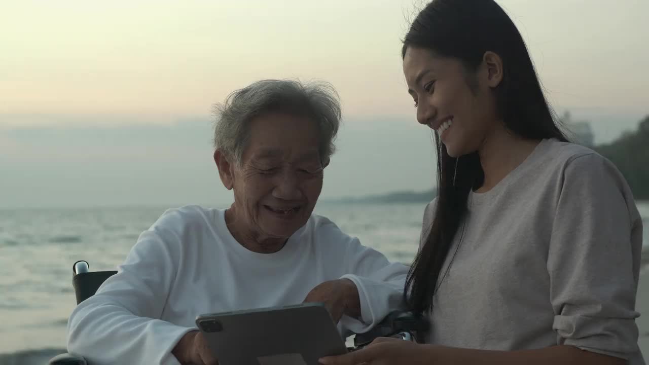 在海上教祖母使用平板电脑的女人。视频素材