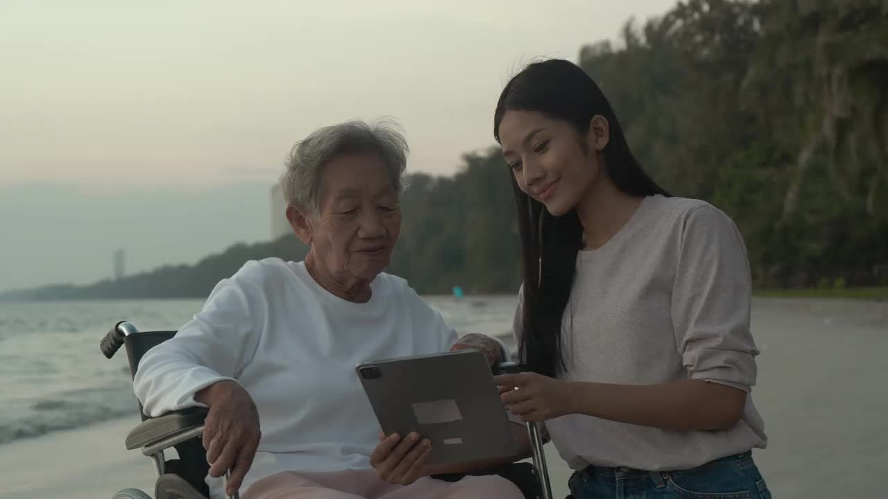 在海上教祖母使用平板电脑的女人。视频素材