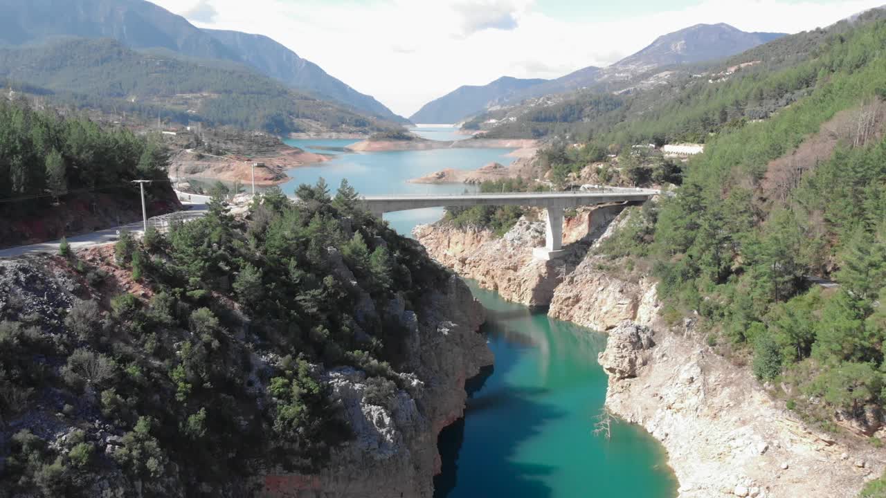 航拍山里的水坝。大坝和水库湖泊产生的水力发电。生产可再生能源，限制全球变暖，可持续的水电视频素材