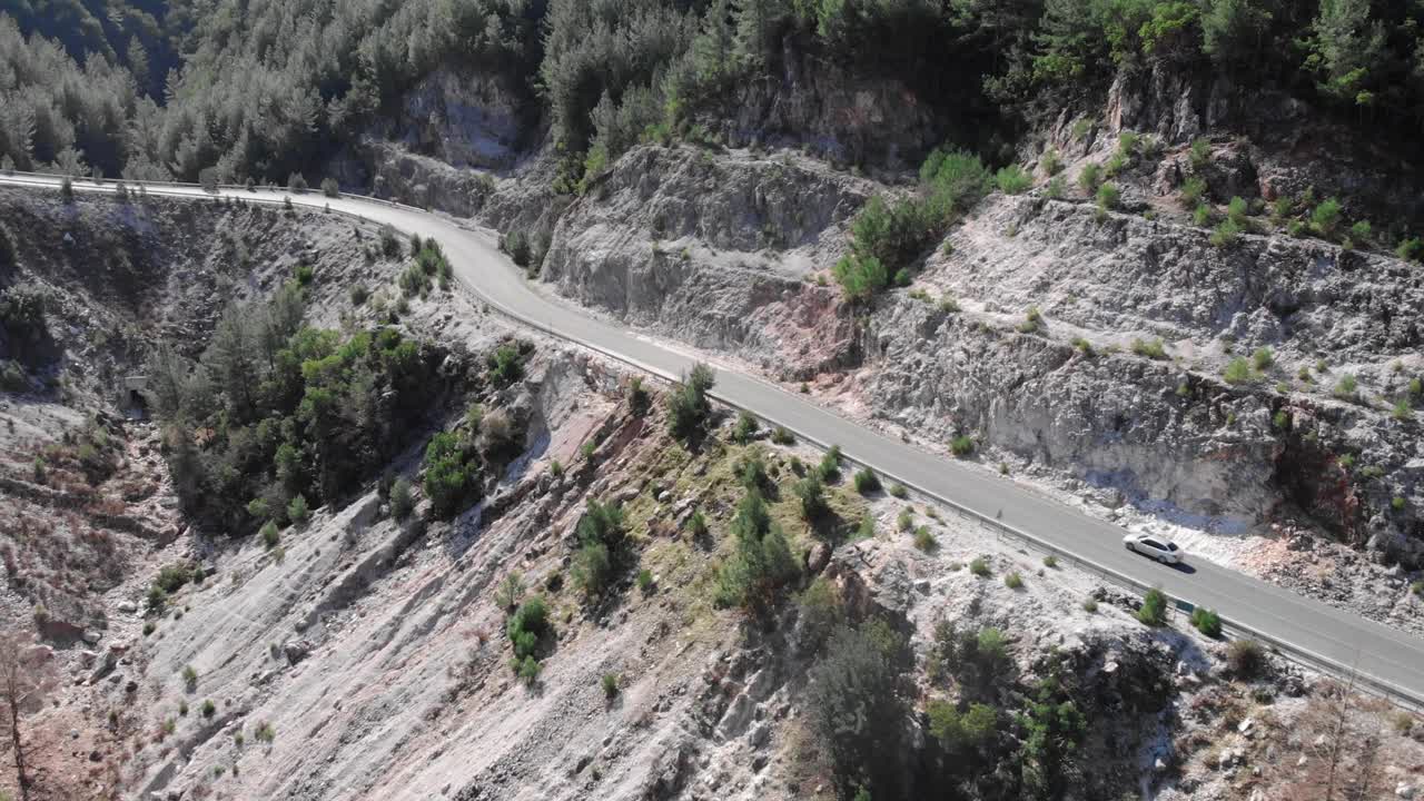 汽车正行驶在穿过山口的空旷道路上。山区的单车道。神奇的森林景观视频素材